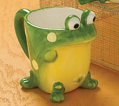 a green frog mug sitting on top of a table