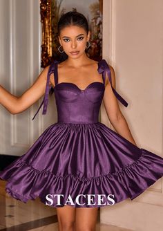 a woman in a purple dress posing for the camera