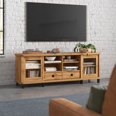 a living room with a large television on the wall and a brown couch in front of it