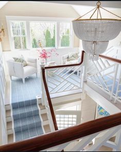 the stairs in this house are decorated with chandelier and blue carpeted rugs