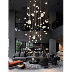 a large living room filled with furniture and lots of lights hanging from it's ceiling