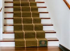 a carpeted stair case in front of a set of stairs