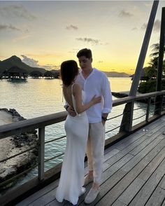 a man and woman standing next to each other on a pier