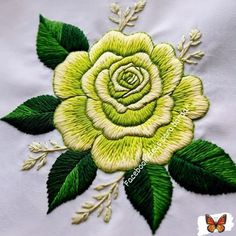 a white rose with green leaves on it's side is embroidered onto the back of a t - shirt