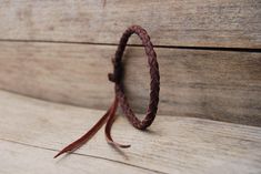 a close up of a leather cord on a wooden surface