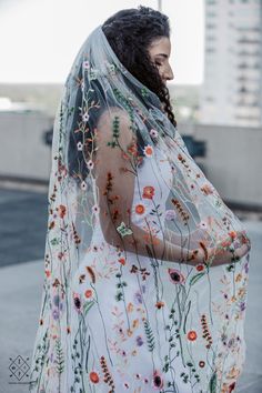 a woman wearing a veil with flowers on it