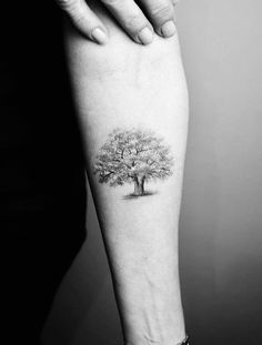 a woman's arm with a tree tattoo on it