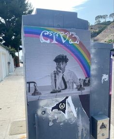 a newspaper dispenser sitting on the side of a road