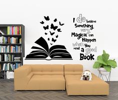 a dog laying on top of a couch in front of a book wall decal