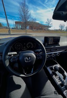 the interior of a car with steering wheel, dashboard and display screen showing various electronic devices