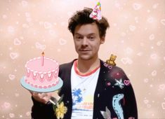 a man holding a birthday cake with candles on it and a candle in his hand