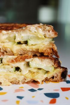 two grilled sandwiches stacked on top of each other with cheese and broccoli