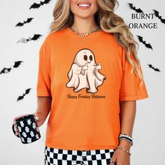 Celebrate Halloween with a sassy twist on my Comfort Colors® t-shirt, featuring a cute but rude ghost flipping the middle finger, with the caption "Happy Freaking Halloween." This cheeky tee is a perfect gift for funny and sarcastic friends, Halloween lovers, and anyone who enjoys a bit of spooky humor. Ideal for fall, spooky season, or year-round wear, this shirt adds a playful touch to any wardrobe! I am open to any sort of customization requests you might desire. My aim is to please! Any desi Funny Orange Tops For Fall, Funny Orange Top For Fall, Funny Halloween T-shirt With Character Print, Spooky Orange Crew Neck Top, Halloween Funny Print Orange T-shirt, Funny Halloween Tops With Character Print, Orange Halloween T-shirt With Funny Print, Orange Crew Neck Top With Character Print, Orange Short Sleeve Tops With Character Print