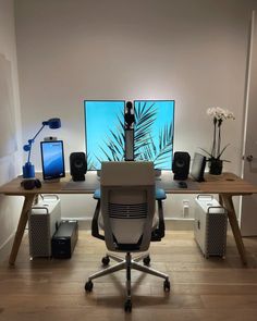 a computer desk with two monitors and speakers on it in front of a white wall