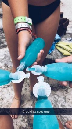 a woman holding a blue water bottle in her hand and another person reaching for it