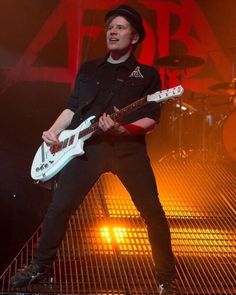 a man with a guitar on stage at a concert