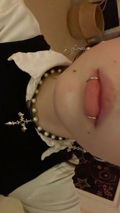 a close up of a person wearing pearls