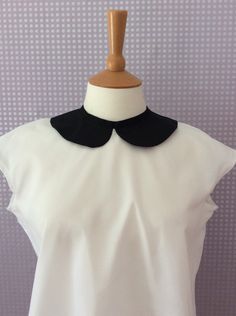 A versatile, simple, button back blouse with a feature Peter Pan collar, this should be in every woman's wardrobe.  This beautifully simple and elegant design is suitable for casual and formal wear and is made from a beautiful white cotton and a contrasting black collar.  Wear with a high waisted skirt, or simple trousers for a striking and comfortable to wear outfit. Size 8 - Bust 33'. Waist 26''  Size 10 - Bust 35''. Waist 28'' Size 12 - Bust 37''. Waist 30'' Size 14 - Bust 39''. Waist 32'' Si Peter Pan Collar Blouse, Blouse Price, Collar Blouse, Womens Blouses, Women's Wardrobe, Wearing Clothes, Pan Collar, Peter Pan Collar, Red Ribbon