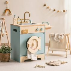 a child's play kitchen with a sink, stove and washing machine in it