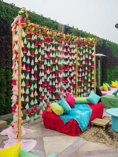 an outdoor seating area is decorated with colorful paper decorations