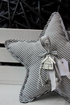 a striped star pillow with a house tag on it