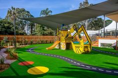 A childcare in Burwood with an excavator machine with slides under sail shades and grass floor. Excavator Machine, Daycare Business Plan, Preschool Montessori, Game Station, Play Area Backyard, Daycare Business, Kindergarten Design, Early Learning Centre