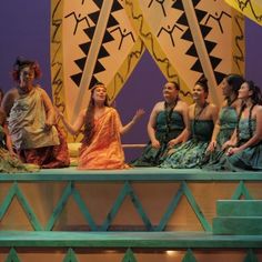 a group of women sitting on top of a stage