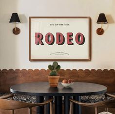 a dining room table with two chairs and a potted plant on the table in front of it