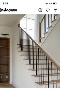 an empty room with a book shelf under the stair railing and open shelves on either side