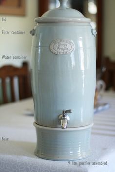 an ice cream dispenser sitting on top of a white tablecloth covered table