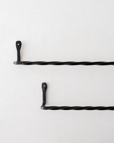 two black hooks are hanging on the wall