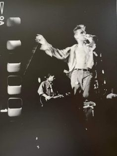 a black and white photo of a man on stage