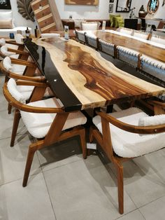 a large wooden table surrounded by white chairs