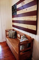 a wooden bench sitting in front of an american flag on a wood paneled wall