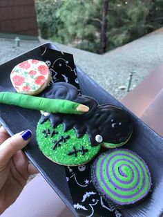 a person is holding a tray with decorated cookies