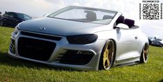 a silver car parked on top of a lush green field