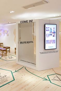 an exhibit booth with white walls and wood floors