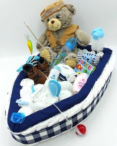 a teddy bear sitting in a basket filled with baby items