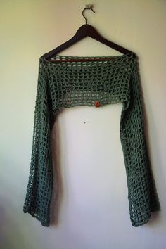 a green crocheted sweater hanging on a wall