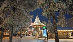 people are walking through the snow in front of a small building with a steeple