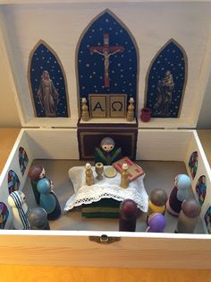 a doll house with furniture and accessories in the box, including a crucifix