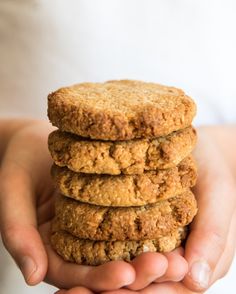 a person holding three cookies in their hands