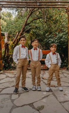 three young boys wearing suspenders and bow ties