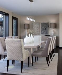 a dining room table with white chairs and a chandelier