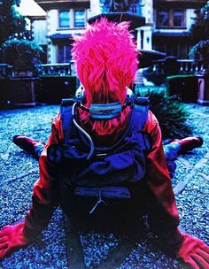 a person with pink hair sitting on the ground