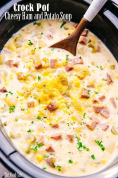 crock pot ham and potato soup with a wooden spoon in the slow cooker