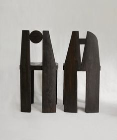 three pieces of wood sitting next to each other on a white surface in front of a gray background