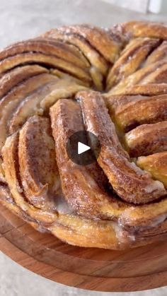 a wooden plate topped with cinnamon rolls on top of a table