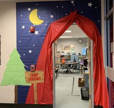 an open door to a classroom decorated with red drapes and trees on the wall