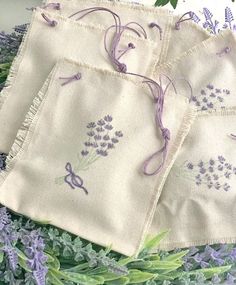 three embroidered napkins with lavender flowers on them